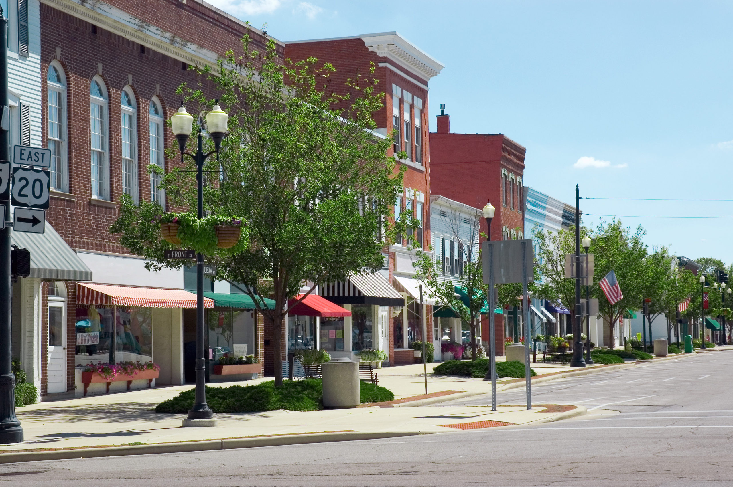Photo of the main street in a typical midwest small town, with U.S. flags outside of several buildings.