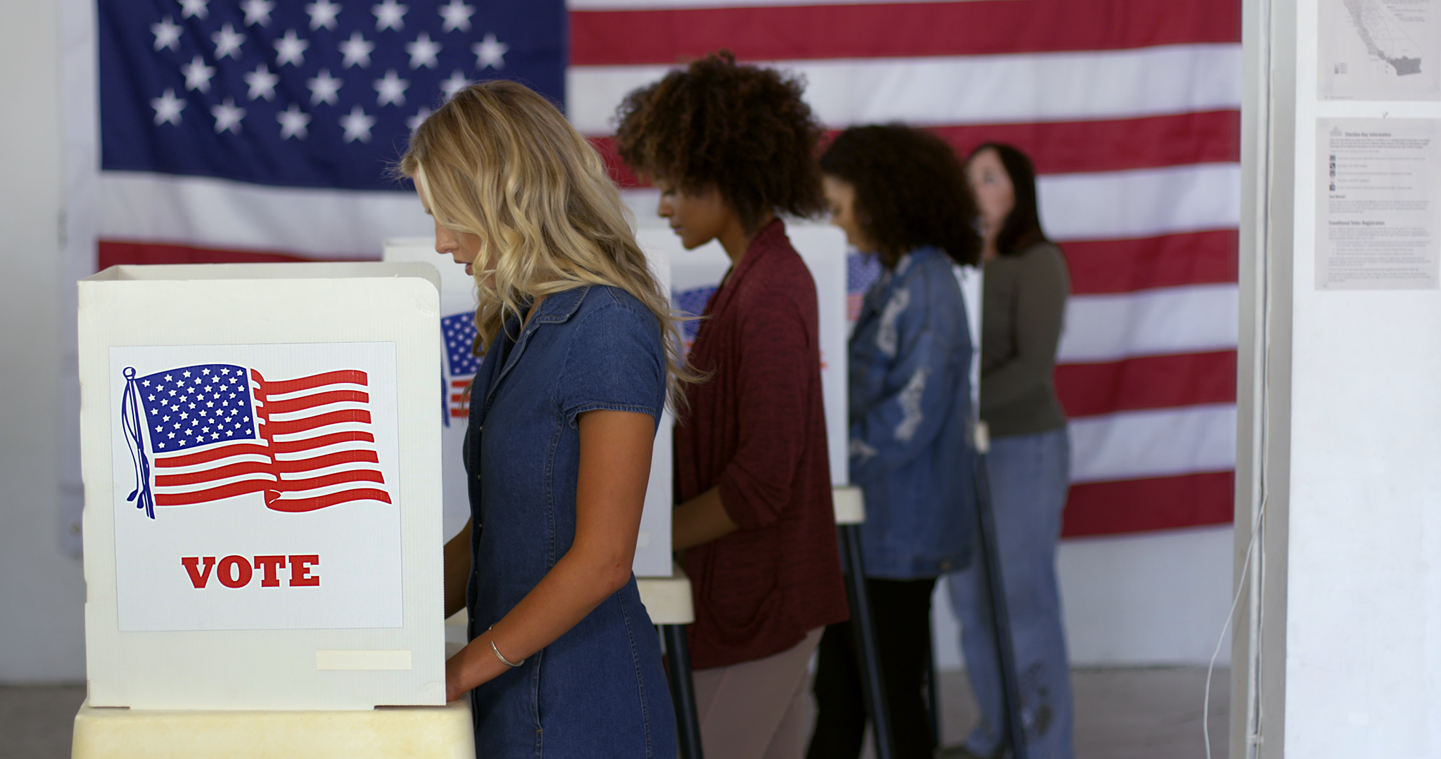 Four women voting at poll booths