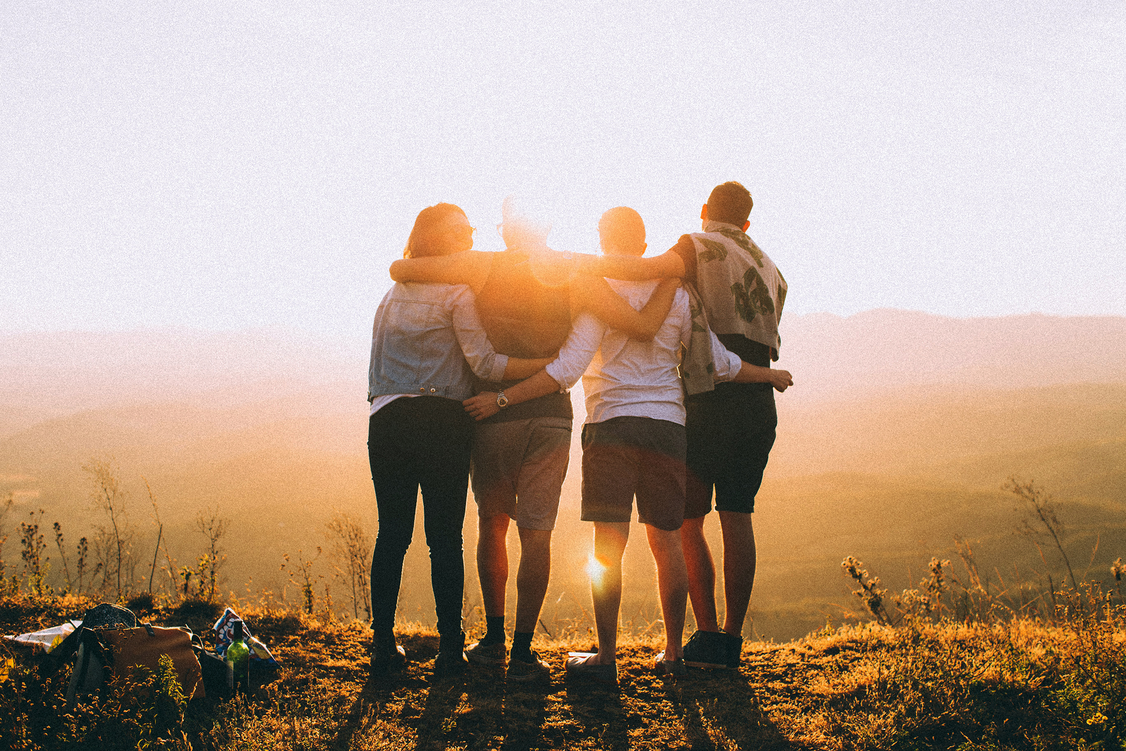 four women hugging at the peak of a hike