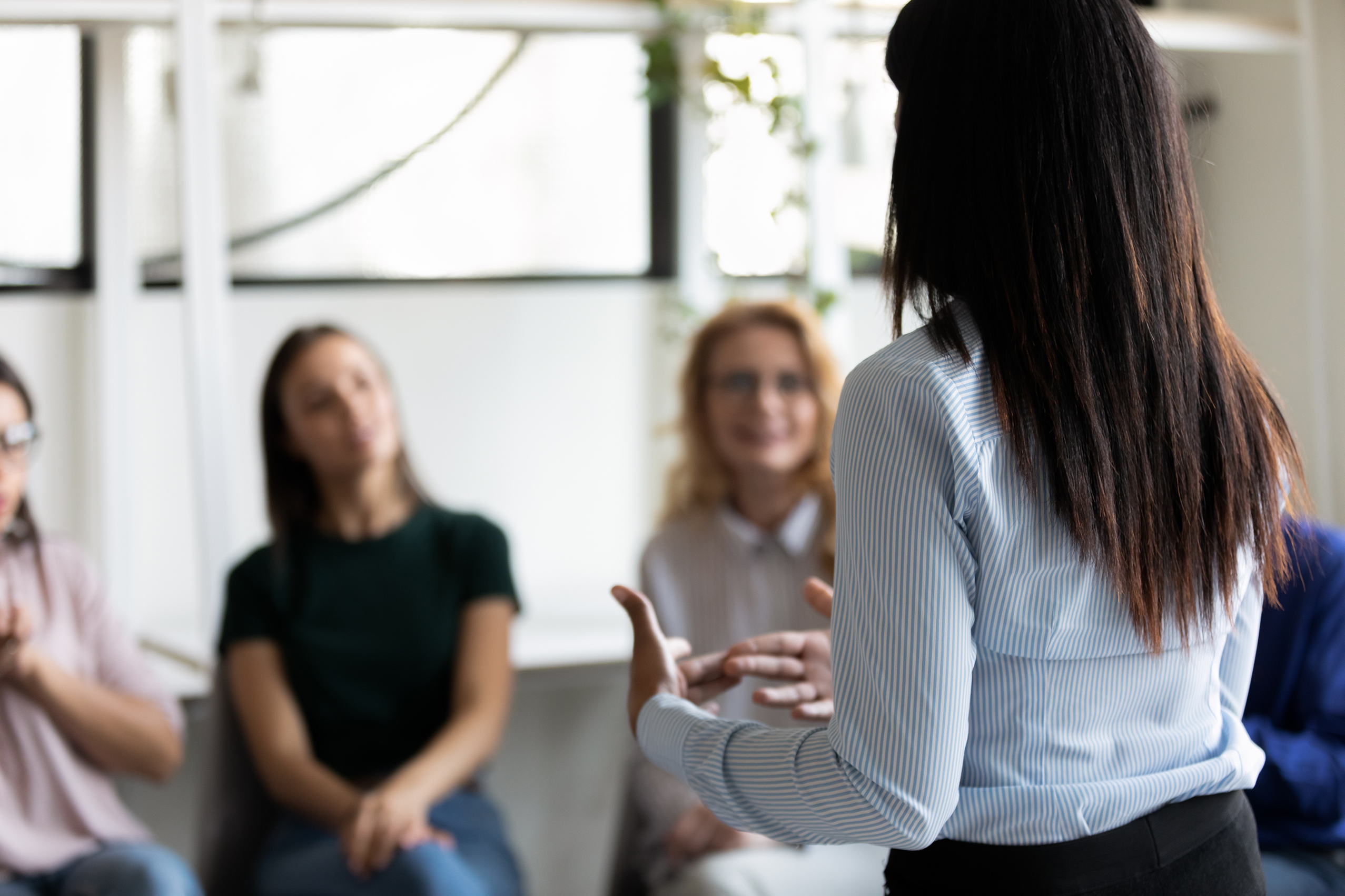 A woman gives a business presentation to other women