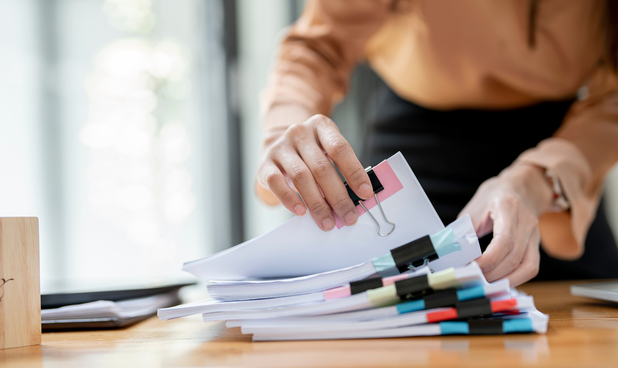 Woman holding piles of research papers