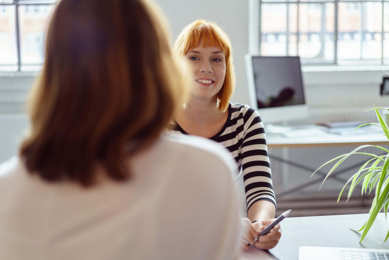 woman smiling looking at person across from them at table