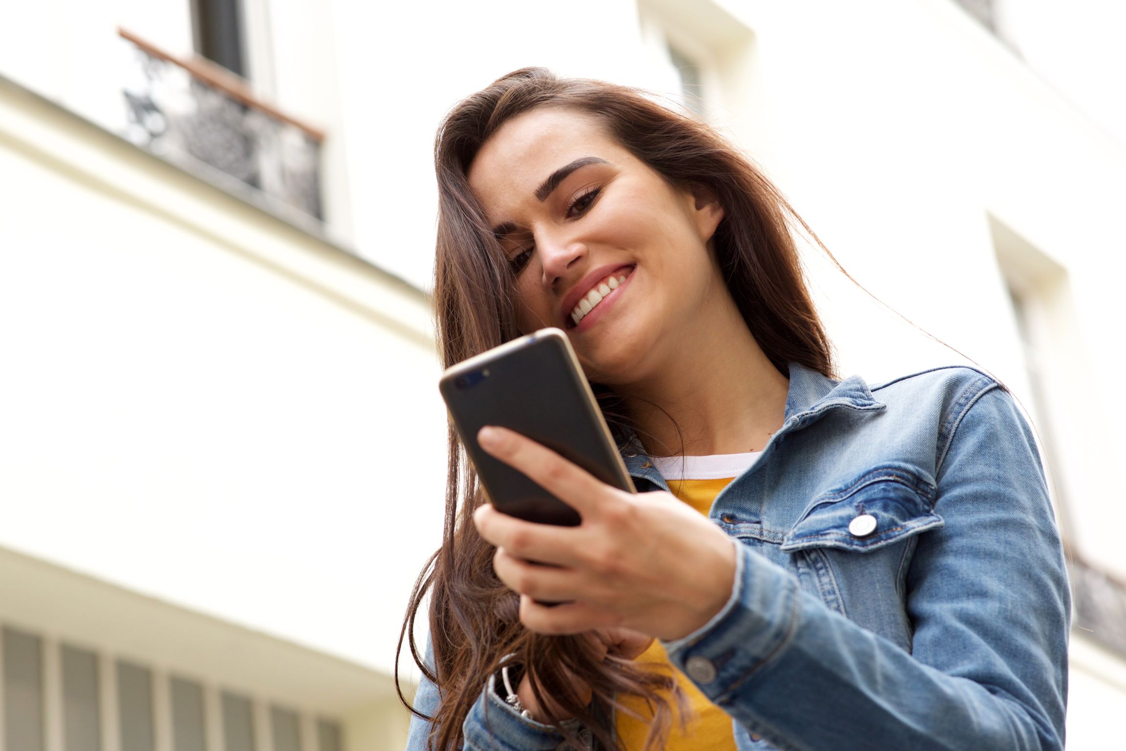 A woman smiles at her phone