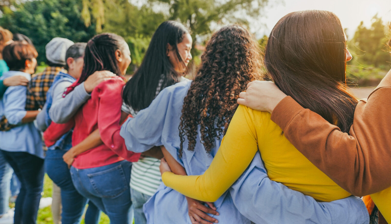 group of women with arms around each other shown from behind