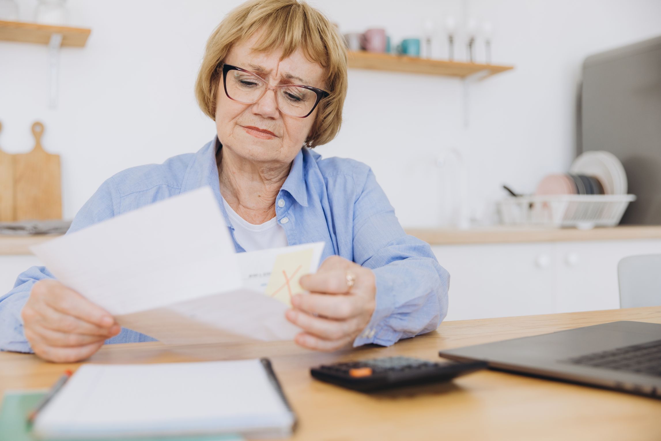 A woman looks thoughtfully over financial papers